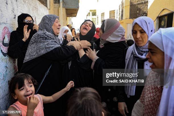 Women mourn during the funeral of members of the Abu Quta family who were killed in Israeli strikes on the Palestinian city of Rafah in the southern Gaza Strip, on October 8, 2023. Fighting between Israeli forces and the Palestinian militant group Hamas raged on October 8, with hundreds killed on both sides after a surprise attack on Israel prompted Prime Minister Benjamin Netanyahu to warn they were "embarking on a long and difficult war". (Photo by SAID KHATIB / AFP) (Photo by SAID KHATIB/AFP via Getty Images)