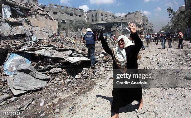 GAZA CITY, GAZA - JULY 20:  Paramedic team and few journalists access to the Shujaya neighborhood of Gaza during the two-hour humanitarian ceasefire proposal from the International Committee of the Red Cross which was accepted by Israel, July 20,2014. People frantically attempted to to pick up the dead and the wounded in the blood strewn area while plumes of smoke from the recent Israeli shelling lingered in the air. The latest Palestinian fatalities figures reached 425 in the unrelenting Israeli air and naval bombardment of the blockaded Gaza Strip since July 7. (Photo by Ashraf Amra/Anadolu Agency/Getty Images)