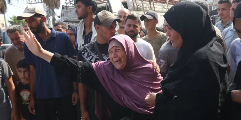 photo-of-a-woman-crying-and-holding-up-her-arm-surrounded-by-others